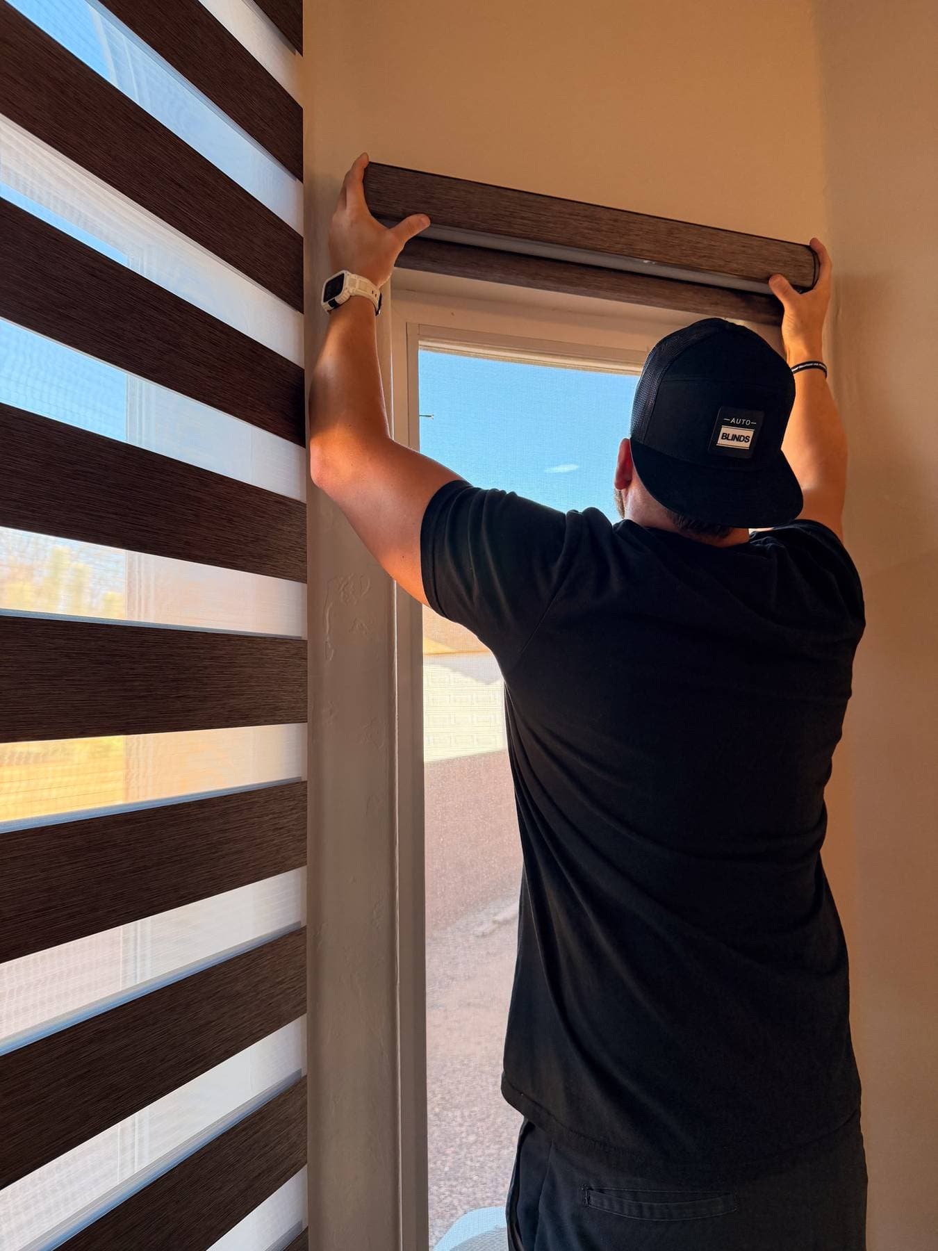 Auto Blinds installer mounting a zebra shade headrail on a new build