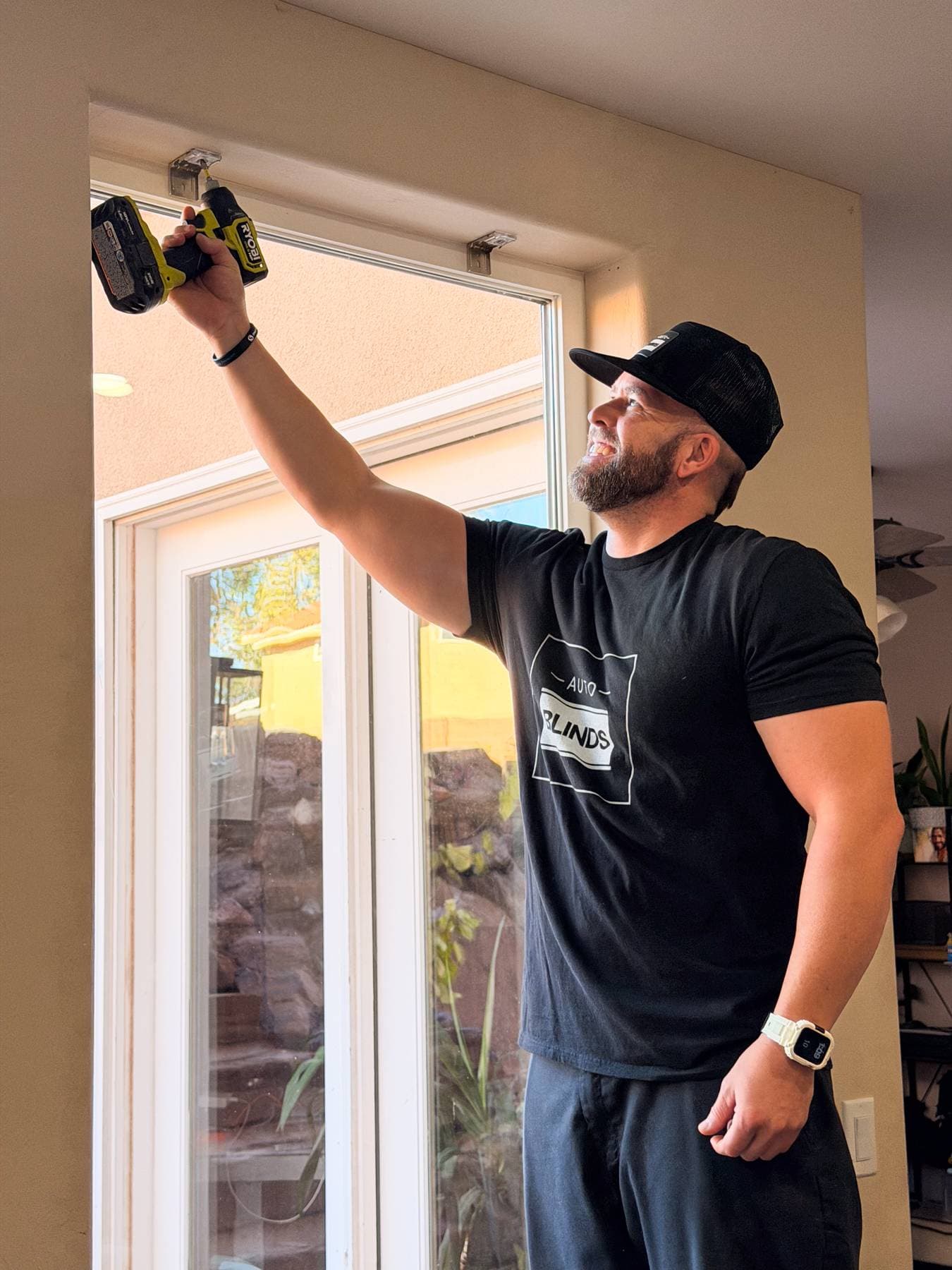 Technician installing motorized blinds in a home